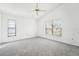 Spacious bedroom with gray carpeting, two windows with blinds, and a ceiling fan at 1830 E Del Webb Blvd, Sun City Center, FL 33573