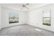 Spacious bedroom with gray carpeting, two windows, and a ceiling fan at 1830 E Del Webb Blvd, Sun City Center, FL 33573