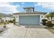 One-story house with light blue garage door and patterned driveway at 1830 E Del Webb Blvd, Sun City Center, FL 33573