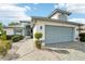 House exterior featuring a two-car garage and a stone paved walkway at 1830 E Del Webb Blvd, Sun City Center, FL 33573