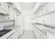 White kitchen with gray countertops and tile floors, includes appliances at 1830 E Del Webb Blvd, Sun City Center, FL 33573