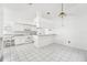 Efficient kitchen with white cabinets, gray countertops, and tile floors at 1830 E Del Webb Blvd, Sun City Center, FL 33573