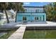 Rear view of waterfront home, featuring a private dock, light blue exterior, and balconies at 3351 Fernleaf Dr, Hernando Beach, FL 34607
