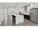 Bright kitchen with an island, stainless steel refrigerator, white cabinets, and modern lighting at 3351 Fernleaf Dr, Hernando Beach, FL 34607