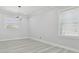 Bright bedroom featuring modern lighting fixture, and light wood floors at 3380 Holly Springs Dr, Hernando Beach, FL 34607
