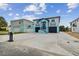 Two-story home with a black roof, garages, balconies, and a striking blue and light-blue color scheme at 3380 Holly Springs Dr, Hernando Beach, FL 34607