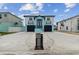 Two-story home with a black roof, garages, balconies, and a striking blue and light-blue color scheme at 3380 Holly Springs Dr, Hernando Beach, FL 34607