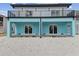 Stunning two-story home with a balcony and sliding glass doors leading to a gravel patio at 3380 Holly Springs Dr, Hernando Beach, FL 34607