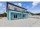 Side view of a beautiful two-story home featuring a balcony and a gravel driveway at 3380 Holly Springs Dr, Hernando Beach, FL 34607