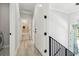 Bright hallway featuring wood floors, white trim, and doors leading to bathroom and stairwell at 3380 Holly Springs Dr, Hernando Beach, FL 34607