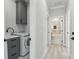 Hallway featuring a laundry area with gray cabinetry and a bathroom with marble tile at 3380 Holly Springs Dr, Hernando Beach, FL 34607