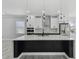 Modern kitchen featuring white cabinetry, a black waterfall island, and stainless steel appliances at 3380 Holly Springs Dr, Hernando Beach, FL 34607