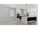 Spacious kitchen with white cabinets, waterfall island, stainless steel appliances, and modern lighting fixtures at 3380 Holly Springs Dr, Hernando Beach, FL 34607