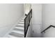 Clean, modern staircase with gray wood-look treads, white risers, and a black metal railing at 3380 Holly Springs Dr, Hernando Beach, FL 34607