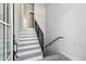Clean, modern staircase with gray wood-look treads, white risers, and a black metal railing at 3380 Holly Springs Dr, Hernando Beach, FL 34607