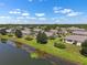 Aerial view of a well-maintained community with lush lawns and a pond with lily pads at 2410 Lancaster Dr, Sun City Center, FL 33573