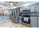 Modern kitchen with stainless steel appliances, gray cabinets, and tiled backsplash at 2410 Lancaster Dr, Sun City Center, FL 33573