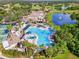 Aerial view of a stunning resort-style pool area with palm trees and luxurious amenities at 2410 Lancaster Dr, Sun City Center, FL 33573