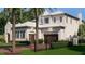 Exterior view showcasing the house and garages, enhanced by vibrant landscaping at 5009 W Spring Lake Dr, Tampa, FL 33629