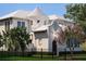 Stunning cream-colored home featuring a unique turret design and manicured landscaping at 5009 W Spring Lake Dr, Tampa, FL 33629