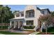 Elegant two-story home features a private balcony, lush landscaping, and a serene water feature at 5009 W Spring Lake Dr, Tampa, FL 33629