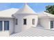 Close-up of a striking turret design with clean white finishes and shuttered windows at 5009 W Spring Lake Dr, Tampa, FL 33629