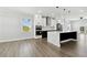 Bright kitchen featuring a large island with black accents, modern appliances, and a view to the outdoor patio at 3230 Azalea Drive # Lot 13, Hernando Beach, FL 34607