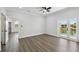 Spacious main bedroom with wood-look flooring, a ceiling fan, and french doors leading to a waterside balcony at 3230 Azalea Drive # Lot 13, Hernando Beach, FL 34607