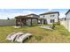 A view of the landscaped backyard, complete with a pergola, bar, and fire pit at 9358 Rally Spring Loop, Wesley Chapel, FL 33545