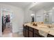 Bathroom with double vanity, walk-in shower, and walk-in closet access at 9358 Rally Spring Loop, Wesley Chapel, FL 33545