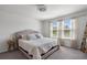 Bedroom with king-size bed, gray carpet, and windows with white blinds at 9358 Rally Spring Loop, Wesley Chapel, FL 33545