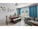 Dining area with table, bench, and couch with large window and blue curtains at 9358 Rally Spring Loop, Wesley Chapel, FL 33545