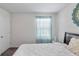 Bedroom with window, neutral decor, and wall art at 9358 Rally Spring Loop, Wesley Chapel, FL 33545