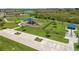 Aerial view of a neighborhood park featuring a playground, dog park, and ample green space at 9358 Rally Spring Loop, Wesley Chapel, FL 33545