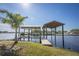Private dock with covered boat lifts on the water at 821 White Heron Blvd, Ruskin, FL 33570