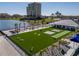 Aerial view of the Beach Club recreation area featuring lawn games, a clubhouse, and a shimmering lake at 140 Riviera Dunes Way # 1403, Palmetto, FL 34221