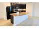 Kitchen boasts dark wood cabinets, granite island, and black appliances at 6949 Crested Orchid Dr, Brooksville, FL 34602