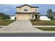 Two story house with beige siding and a two car garage at 6949 Crested Orchid Dr, Brooksville, FL 34602