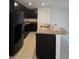 Kitchen with dark cabinetry, granite countertops, and black appliances at 6949 Crested Orchid Dr, Brooksville, FL 34602