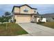 Two story house with beige siding and a two car garage at 6949 Crested Orchid Dr, Brooksville, FL 34602