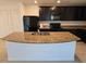 Modern kitchen with granite countertops, black appliances, and an island at 6949 Crested Orchid Dr, Brooksville, FL 34602