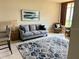 Living room with grey couch and patterned rug at 140 Riviera Dunes Way # 1403, Palmetto, FL 34221