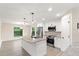 Modern kitchen with white shaker cabinets, granite island, and stainless steel appliances at 156 Haddock Dr, Rotonda West, FL 33947