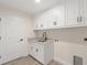 Laundry room with white cabinets, granite countertop, and sink at 156 Haddock Dr, Rotonda West, FL 33947