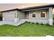 Newly built home showcasing a modern design, light green exterior, and a well-maintained lawn at 156 Haddock Dr, Rotonda West, FL 33947