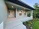 Charming front porch with a beige door and lush landscaping at 156 Haddock Dr, Rotonda West, FL 33947