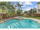 Resort-style pool with spa, grassy area, and wooden fence at 5002 W Homer Ave, Tampa, FL 33629