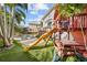 Large backyard featuring a playset on artificial turf, with a glimpse of the pool at 5002 W Homer Ave, Tampa, FL 33629