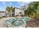 Inviting backyard with pool, spa, deck, and lush landscaping, creating a perfect space for relaxation at 5002 W Homer Ave, Tampa, FL 33629