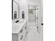 Clean bathroom with white vanity, black hardware, white marble floors, and a shower-tub combination at 5002 W Homer Ave, Tampa, FL 33629